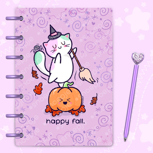 Laminated planner cover with a white witch kawaii cat standing on a laughing pumpkin and dancing spider