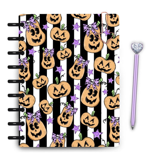 Cute halloween pumpkin faces with purple skull bows on black and white stripes laminated planner cover by magpie soul 