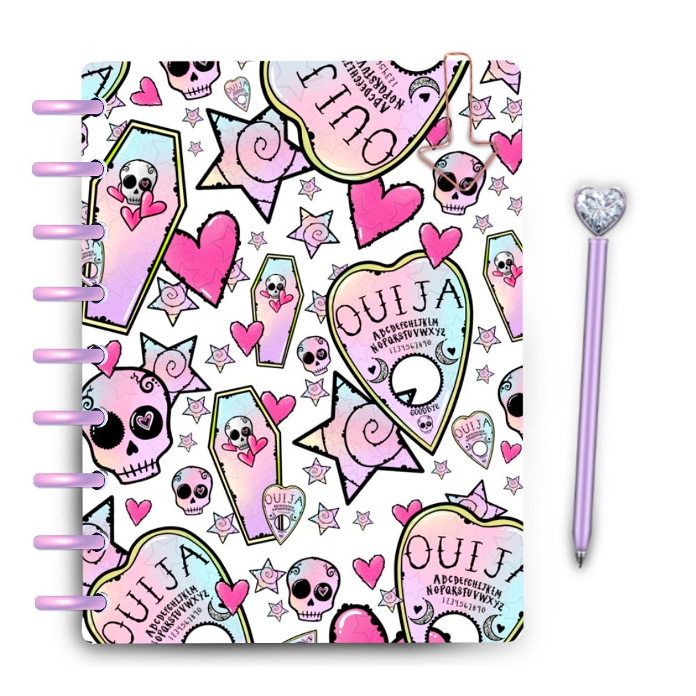 Laminated planner cover with pastel Ouija planchettes, skulls and coffins